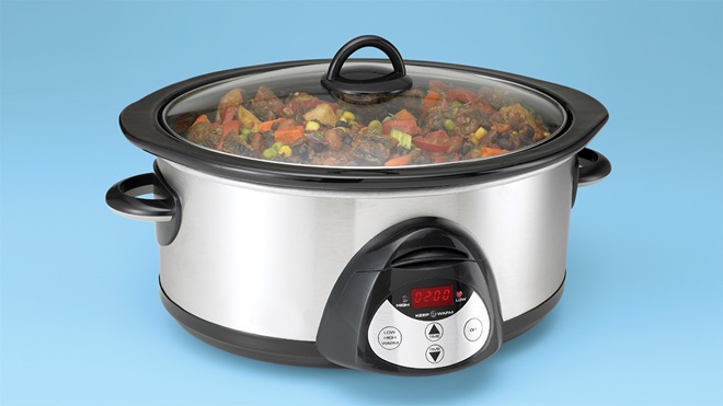 beef and vegetable stew cooking in a slow cooker on a blue background